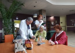 lekarz pielęgniarka i podopieczni na holu hospicjum stacjonarnego
